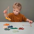Niño jugando con el juego de pesca de madera Trixie